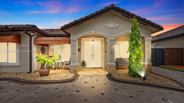 8775 NW 168th St, Miami Lakes, FL 33018 - exterior entry at dusk featuring stucco siding and a tile roof