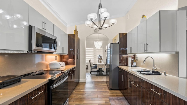 8775 NW 168th St, Miami Lakes, FL 33018 - kitchen with stainless steel appliances, a chandelier, light wood finished floors, light countertops, and backsplash
