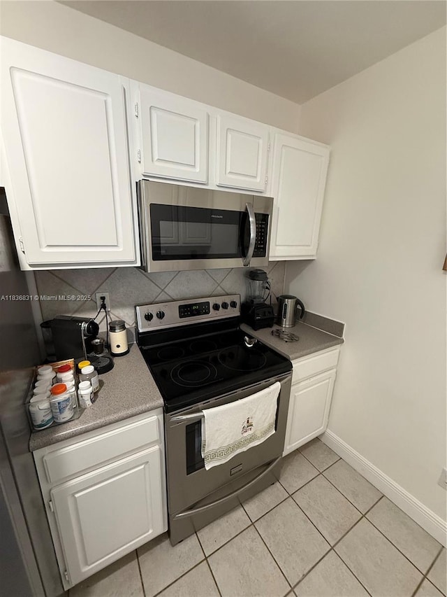 2665 SW 37th Ave Unit 1213, Miami, FL 33133 - kitchen with stainless steel appliances, white cabinets, tasteful backsplash, and light tile patterned flooring