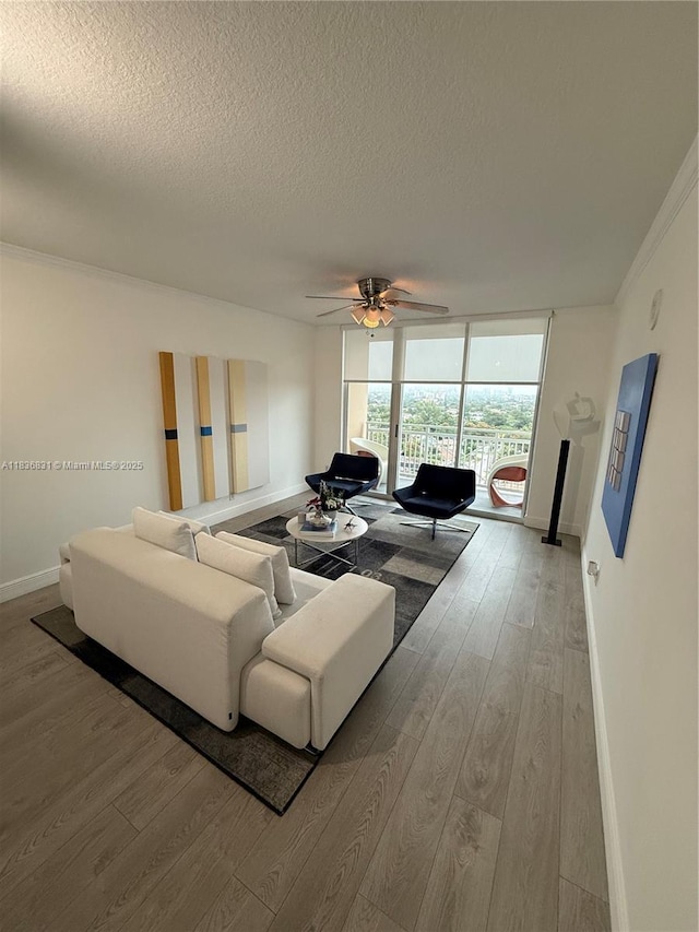 2665 SW 37th Ave Unit 1213, Miami, FL 33133 - living room with light wood-style flooring, a textured ceiling, ceiling fan, crown molding, and expansive windows