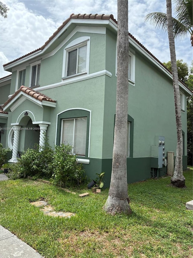 1549 SE 24th Ct Unit 225, Homestead, FL 33035 - view of side of home featuring a tile roof, stucco siding, and a yard