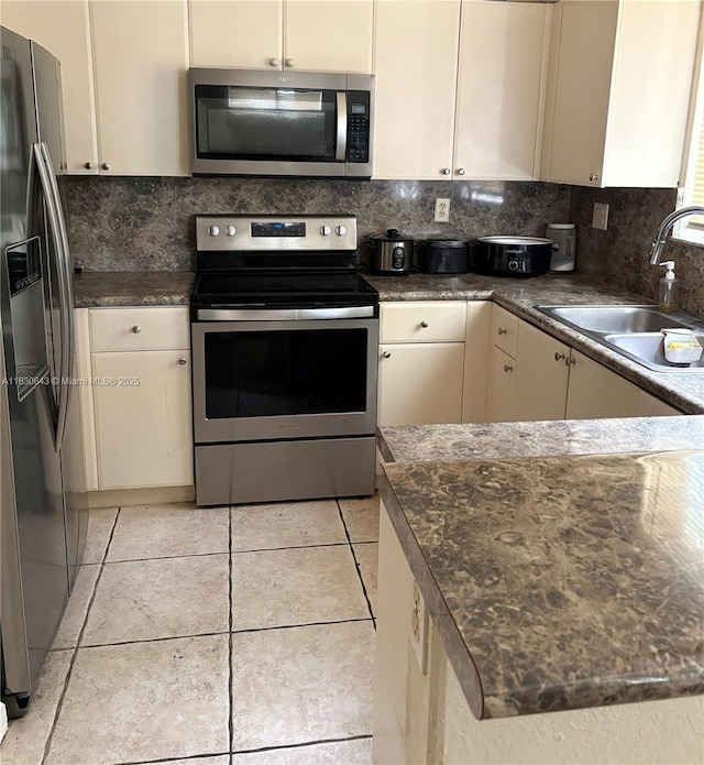 1549 SE 24th Ct Unit 225, Homestead, FL 33035 - kitchen with stainless steel appliances, decorative backsplash, dark countertops, and light tile patterned flooring