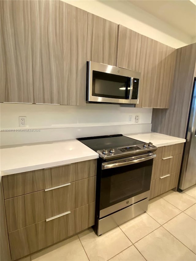 10455 NW 82nd St Unit 33, Doral, FL 33178 - kitchen with stainless steel appliances, modern cabinets, and light tile patterned flooring
