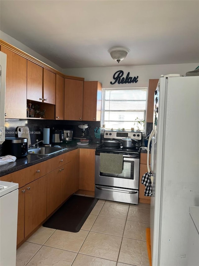 2651 NW 13th St Unit 45, Miami, FL 33125 - kitchen with stainless steel electric stove, freestanding refrigerator, light tile patterned flooring, range, and tasteful backsplash