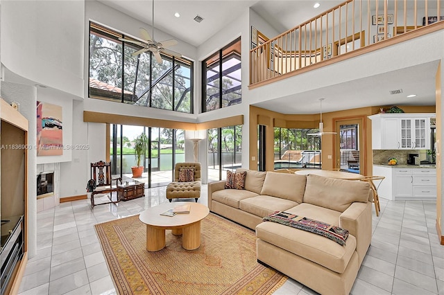 1910 Preston Trl, Coral Springs, FL 33071 - living area with light tile patterned floors, ceiling fan, a tile fireplace, a high ceiling, and recessed lighting