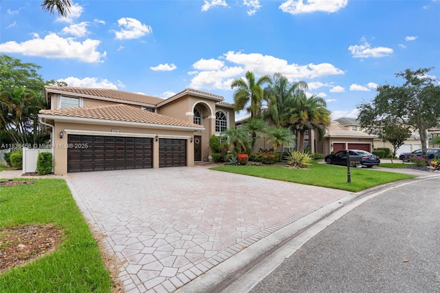 5920 NW 54th Cir, Coral Springs, FL 33067 - mediterranean / spanish-style home featuring a front yard, decorative driveway, stucco siding, and an attached garage