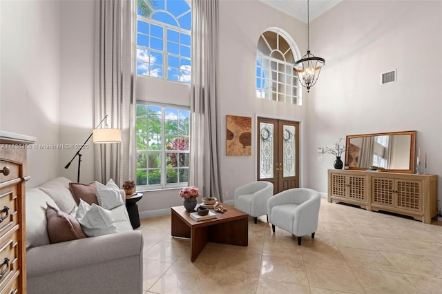 5920 NW 54th Cir, Coral Springs, FL 33067 - living room featuring a chandelier, a high ceiling, french doors, crown molding, and light tile patterned floors