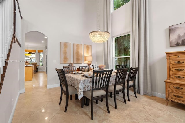 5920 NW 54th Cir, Coral Springs, FL 33067 - dining area featuring a high ceiling, arched walkways, light tile patterned flooring, and a chandelier