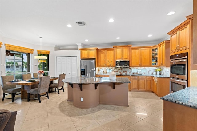 5920 NW 54th Cir, Coral Springs, FL 33067 - kitchen with stainless steel appliances, brown cabinets, dark stone counters, a breakfast bar area, and backsplash