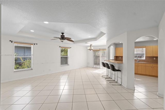 955 S 26th Ave, Hollywood, FL 33020 - unfurnished living room featuring a tray ceiling, a textured ceiling, a chandelier, a ceiling fan, and recessed lighting