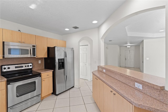 955 S 26th Ave, Hollywood, FL 33020 - kitchen featuring stainless steel appliances, light brown cabinets, arched walkways, light tile patterned floors, and recessed lighting