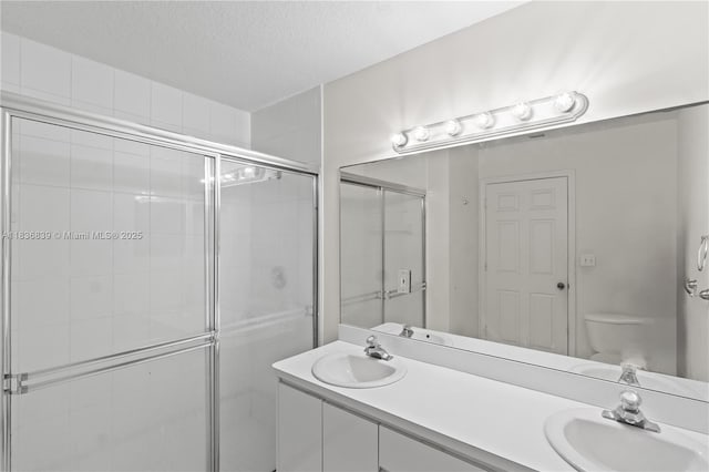 955 S 26th Ave, Hollywood, FL 33020 - bathroom featuring a stall shower, double vanity, and a textured ceiling