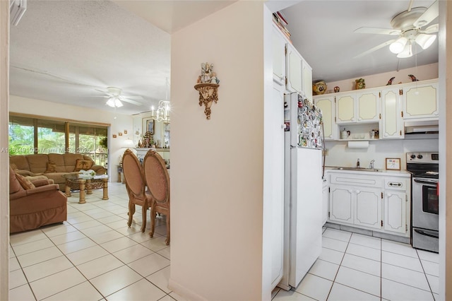 5100 Washington St Unit 211, Hollywood, FL 33021 - kitchen featuring stainless steel electric range oven, freestanding refrigerator, ceiling fan, open floor plan, and light tile patterned floors