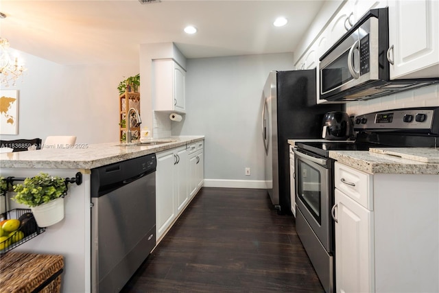 1606 Veracruz Ln, Weston, FL 33327 - kitchen with stainless steel appliances, dark wood finished floors, white cabinetry, a peninsula, and recessed lighting