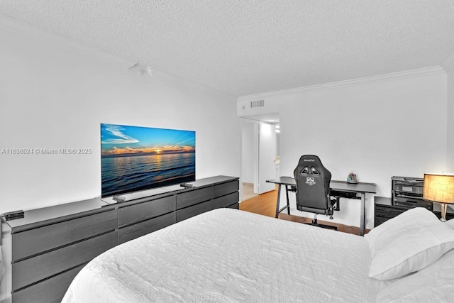 8855 E Collins Ave Unit 2F, Surfside, FL 33154 - bedroom featuring crown molding, a textured ceiling, and wood finished floors