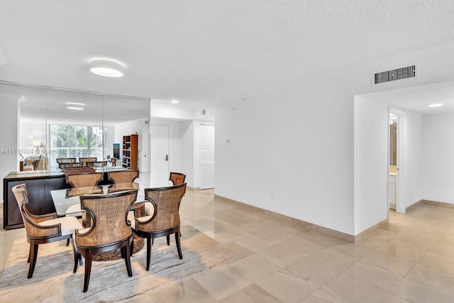 8855 E Collins Ave Unit 2F, Surfside, FL 33154 - dining room with a textured ceiling and light tile patterned floors