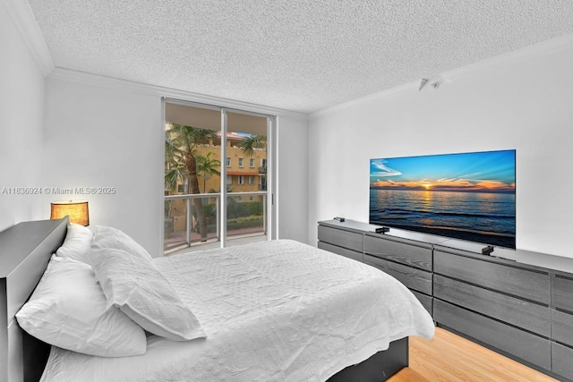 8855 E Collins Ave Unit 2F, Surfside, FL 33154 - bedroom featuring a textured ceiling, crown molding, and light wood finished floors