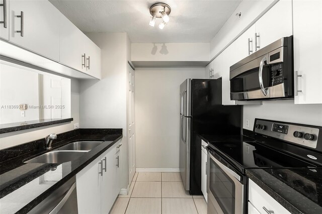 12136 Saint Andrews Pl Unit 204, Miramar, FL 33025 - kitchen featuring stainless steel appliances, white cabinetry, dark stone countertops, and light tile patterned floors