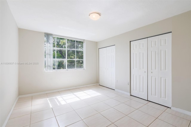 12136 Saint Andrews Pl Unit 204, Miramar, FL 33025 - unfurnished bedroom featuring two closets and light tile patterned floors