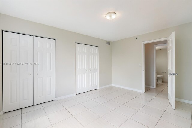 12136 Saint Andrews Pl Unit 204, Miramar, FL 33025 - unfurnished bedroom featuring multiple closets and light tile patterned floors