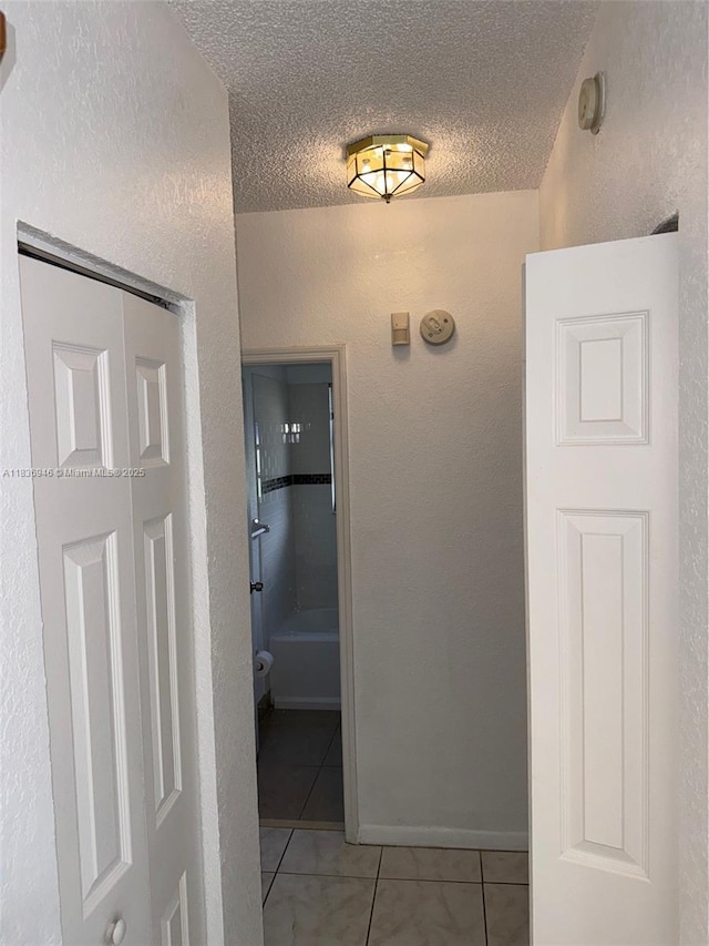5201 SW 31st Ave Unit 112, Dania Beach, FL 33312 - hallway featuring light tile patterned floors, a textured ceiling, and a textured wall