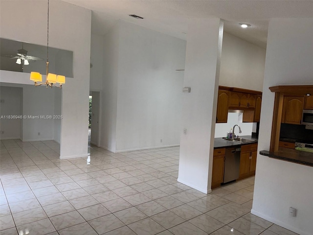 5201 SW 31st Ave Unit 112, Dania Beach, FL 33312 - kitchen with high vaulted ceiling, appliances with stainless steel finishes, dark countertops, a chandelier, and light tile patterned floors