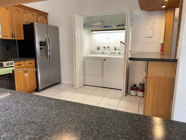 5201 SW 31st Ave Unit 112, Dania Beach, FL 33312 - kitchen with independent washer and dryer, stainless steel fridge with ice dispenser, stove, and light tile patterned flooring