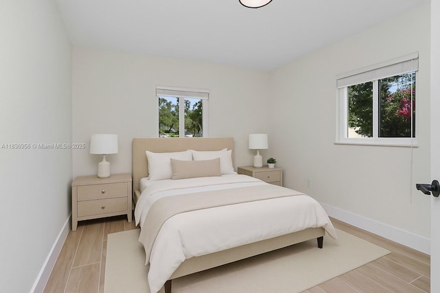 990 NE 159th St, North Miami Beach, FL 33162 - bedroom featuring multiple windows and light wood-style flooring