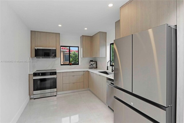 231 NE 45th St, Miami, FL 33137 - kitchen with appliances with stainless steel finishes, light brown cabinetry, light countertops, modern cabinets, and recessed lighting