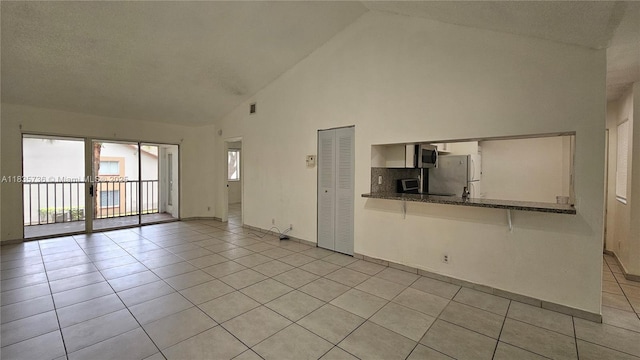 9277 SW 138th Pl Unit 9277, Miami, FL 33186 - empty room with light tile patterned floors and high vaulted ceiling