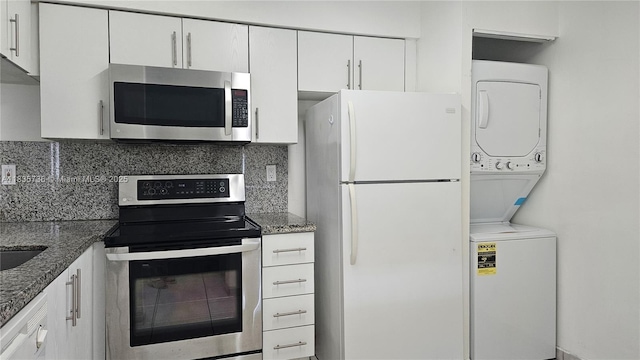 9277 SW 138th Pl Unit 9277, Miami, FL 33186 - kitchen with stainless steel appliances, estacked washer and dryer, white cabinets, and decorative backsplash
