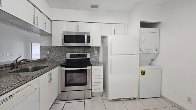 9277 SW 138th Pl Unit 9277, Miami, FL 33186 - kitchen with appliances with stainless steel finishes, stacked washer / drying machine, white cabinets, and light tile patterned floors