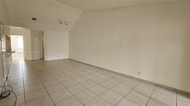 9277 SW 138th Pl Unit 9277, Miami, FL 33186 - spare room featuring vaulted ceiling, light tile patterned floors, and rail lighting
