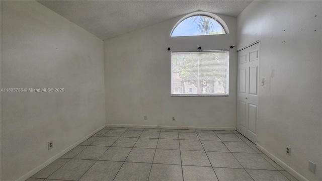 9277 SW 138th Pl Unit 9277, Miami, FL 33186 - empty room featuring vaulted ceiling, light tile patterned flooring, and a textured ceiling