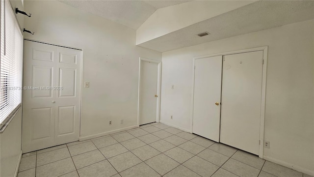 9277 SW 138th Pl Unit 9277, Miami, FL 33186 - unfurnished bedroom with light tile patterned flooring, lofted ceiling, a textured ceiling, and a closet