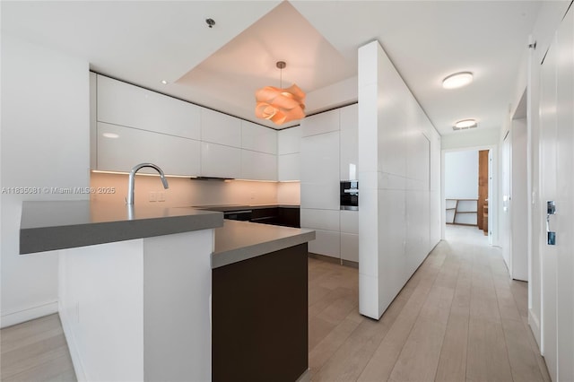 2681 N Flamingo Rd Unit 2708S, Sunrise, FL 33323 - kitchen with modern cabinets, a peninsula, white cabinetry, light wood-style floors, and hanging light fixtures