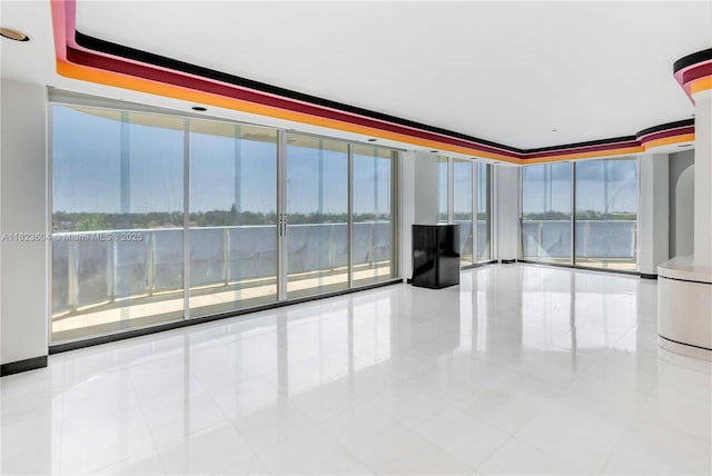 3802 NE 207th St Unit 601, Aventura, FL 33180 - tiled empty room featuring a water view, plenty of natural light, and floor to ceiling windows