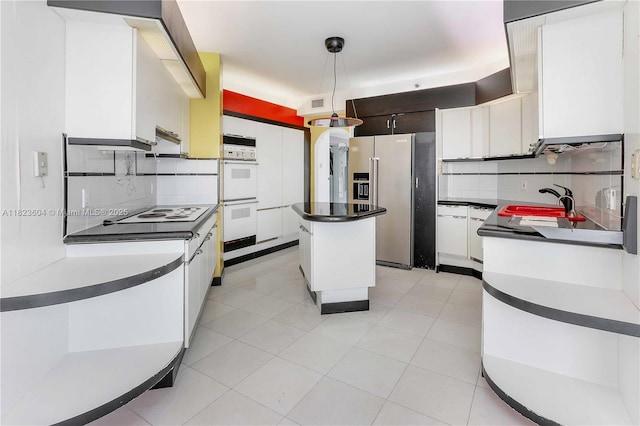 3802 NE 207th St Unit 601, Aventura, FL 33180 - kitchen featuring white appliances, decorative backsplash, dark countertops, a kitchen island, and white cabinetry