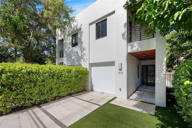 3070 Elizabeth St, Miami, FL 33133 - back of house featuring stucco siding, an attached garage, and driveway