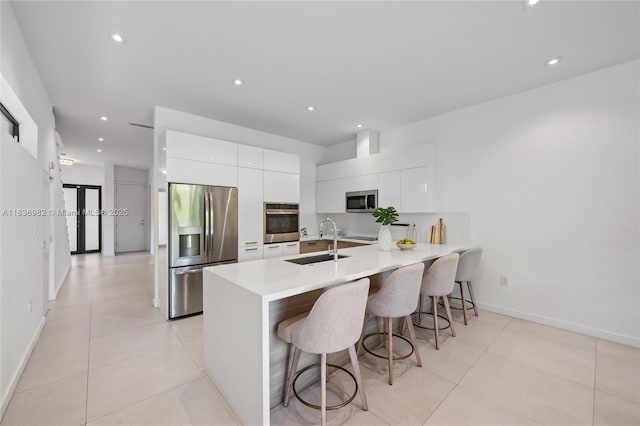 3070 Elizabeth St, Miami, FL 33133 - kitchen with appliances with stainless steel finishes, modern cabinets, white cabinetry, a breakfast bar, and a peninsula