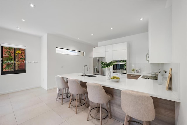 3070 Elizabeth St, Miami, FL 33133 - kitchen featuring stainless steel appliances, light countertops, modern cabinets, white cabinetry, and a peninsula