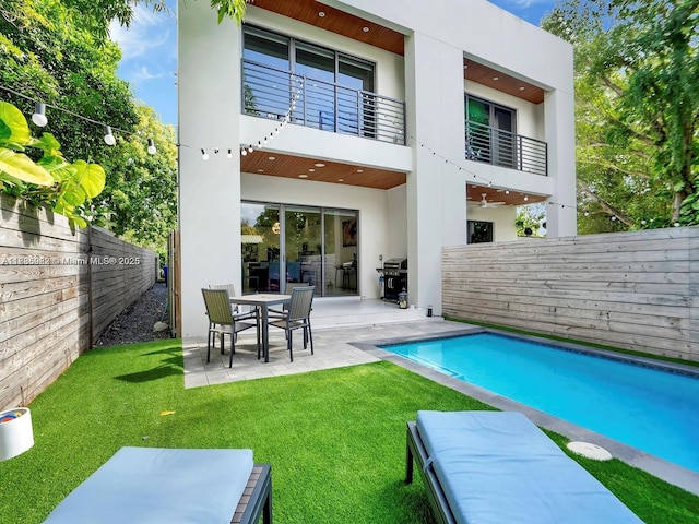 3070 Elizabeth St, Miami, FL 33133 - rear view of property featuring stucco siding, a balcony, a fenced backyard, and a patio