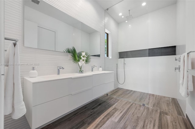 3070 Elizabeth St, Miami, FL 33133 - full bath with tile walls, double vanity, wood finished floors, a walk in shower, and recessed lighting