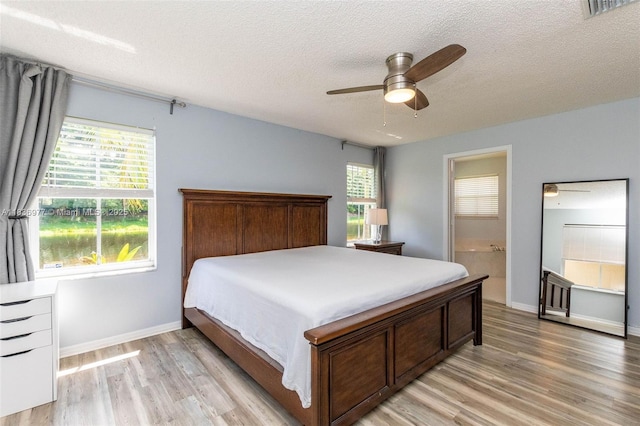 2020 Andromeda Ln, Weston, FL 33327 - bedroom with light wood-style flooring, a textured ceiling, connected bathroom, and ceiling fan