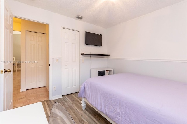 2020 Andromeda Ln, Weston, FL 33327 - bedroom with light wood-type flooring, a closet, and a textured ceiling