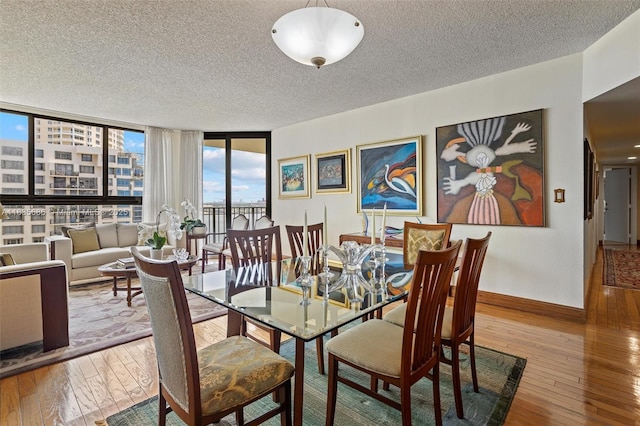 520 Brickell Key Dr Unit A1404, Miami, FL 33131 - dining space featuring hardwood / wood-style floors, a textured ceiling, plenty of natural light, and a wall of windows