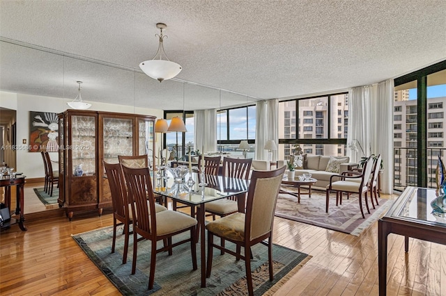 520 Brickell Key Dr Unit A1404, Miami, FL 33131 - dining room featuring a textured ceiling, light wood-type flooring, healthy amount of natural light, and expansive windows