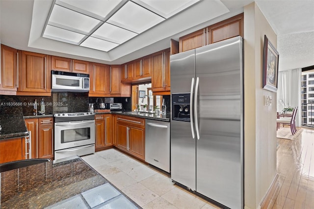 520 Brickell Key Dr Unit A1404, Miami, FL 33131 - kitchen featuring stainless steel appliances, tasteful backsplash, and brown cabinetry