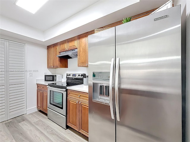 1309 SW 75th Ave, North Lauderdale, FL 33068 - kitchen with stainless steel appliances, under cabinet range hood, light wood-type flooring, and brown cabinetry