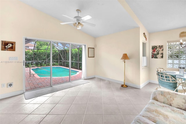 living room featuring ceiling fan, lofted ceiling, light tile patterned floors, and a sunroom